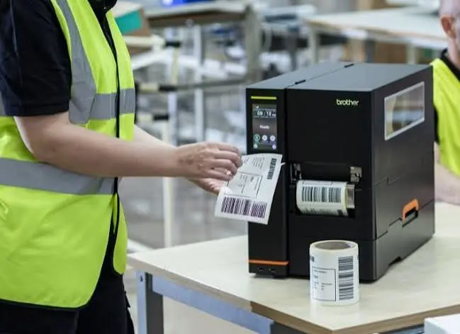 Brother TITAN industrial label printer producing barcode labels in a production environment